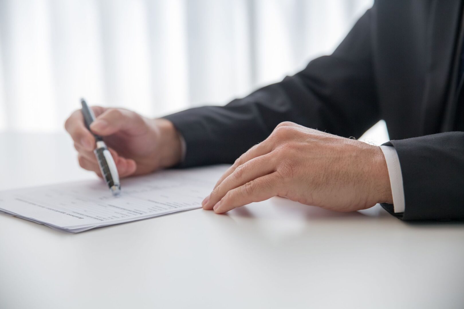 Hands signing a notarized affidavit of service at a desk